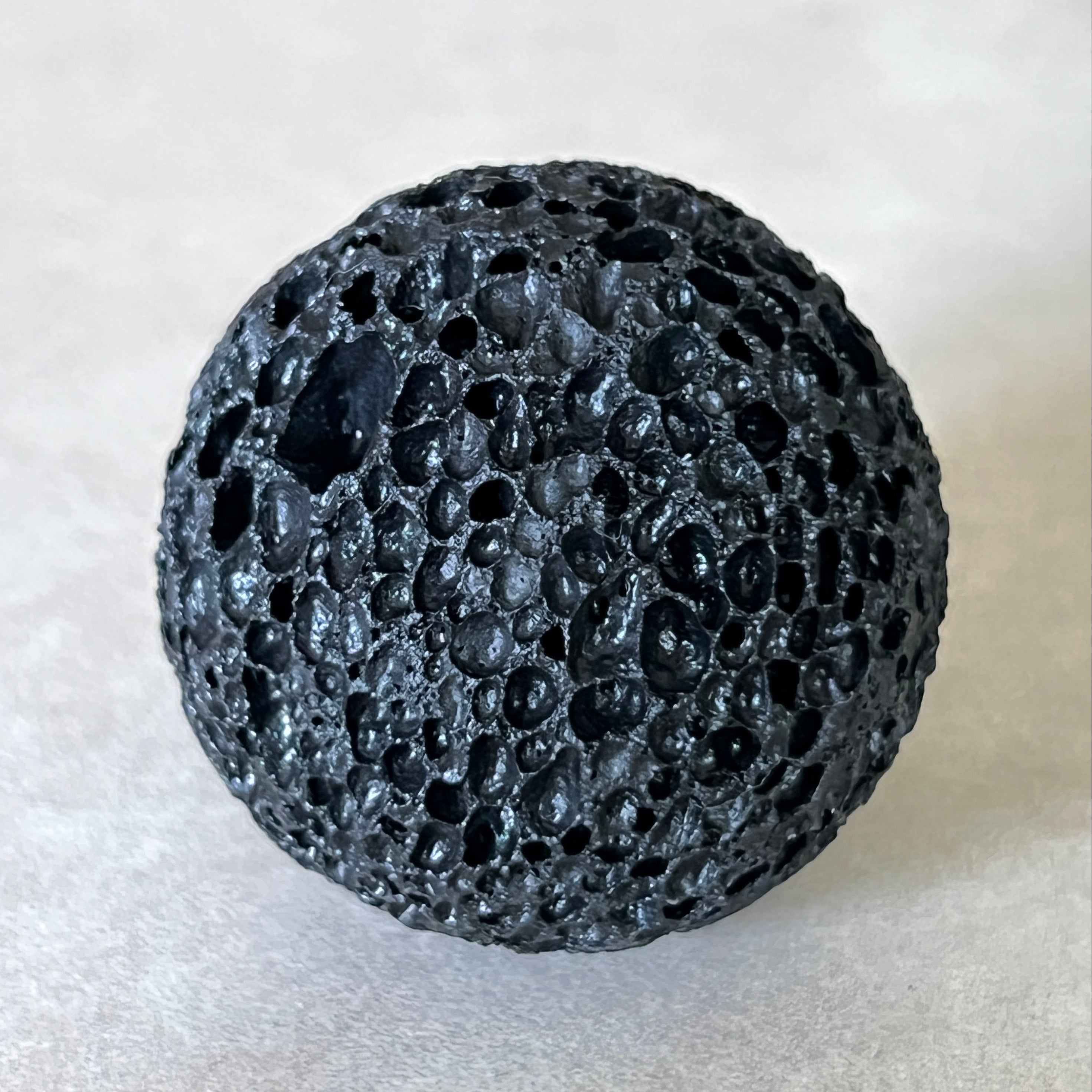 Black Komodo stone ball on a white background